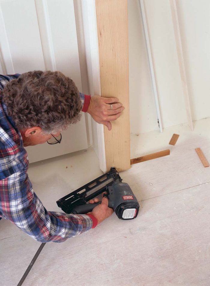 Shim the jamb, and nail it home. Once the jamb has been plumbed, it can be permanently affixed to the trimmer.
