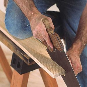 Notching the stool. Although he uses a miter saw to make the crosscut, the author prefers a handsaw for the rip.