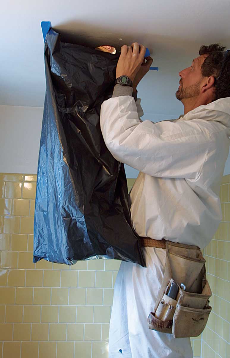 Cheap and easy dust containment. A garbage bag taped to the bathroom ceiling catches dust while the ceiling is cut. A plastic suit (available at paint stores for less than $10) protects your skin from fiberglass insulation and dust in the attic.