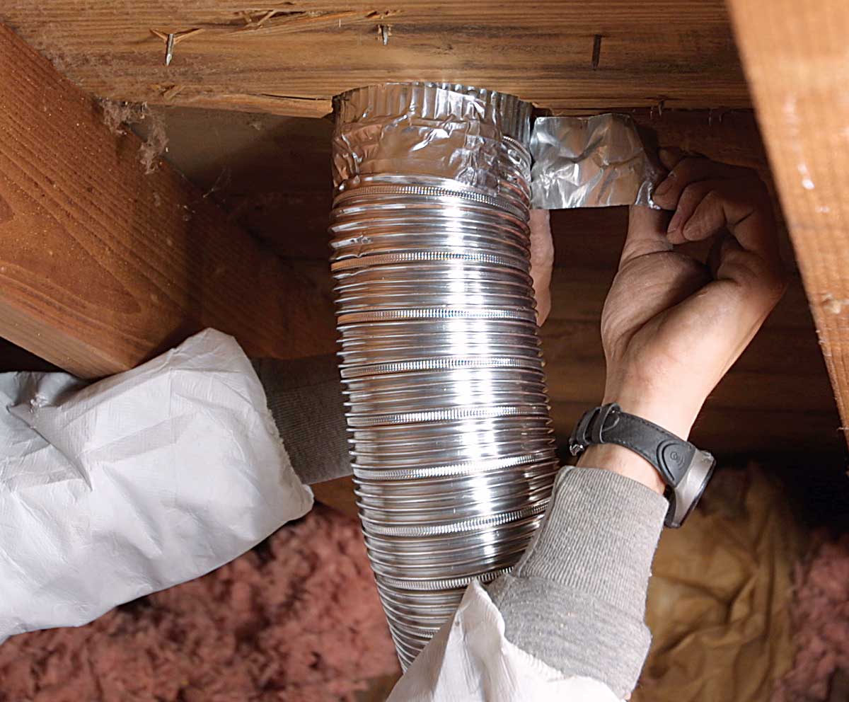 Connect the duct. Back in the attic, the duct is connected to the vent and sealed with aluminum duct tape.