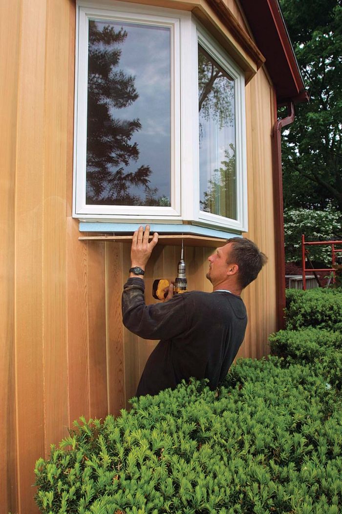 A piece of foam insulation and 1⁄2-in. plywood cut to the shape of the window help to prevent heat loss below the large window.