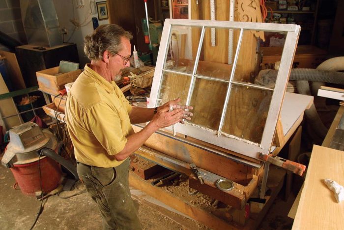 With the sash propped up on a homemade easel, he works glazing compound into a 3⁄8-in.-diarope before pressing it into place.