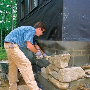 measure the rock faces to keep them plumb for the stone veneer