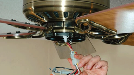 person installing a ceiling fan