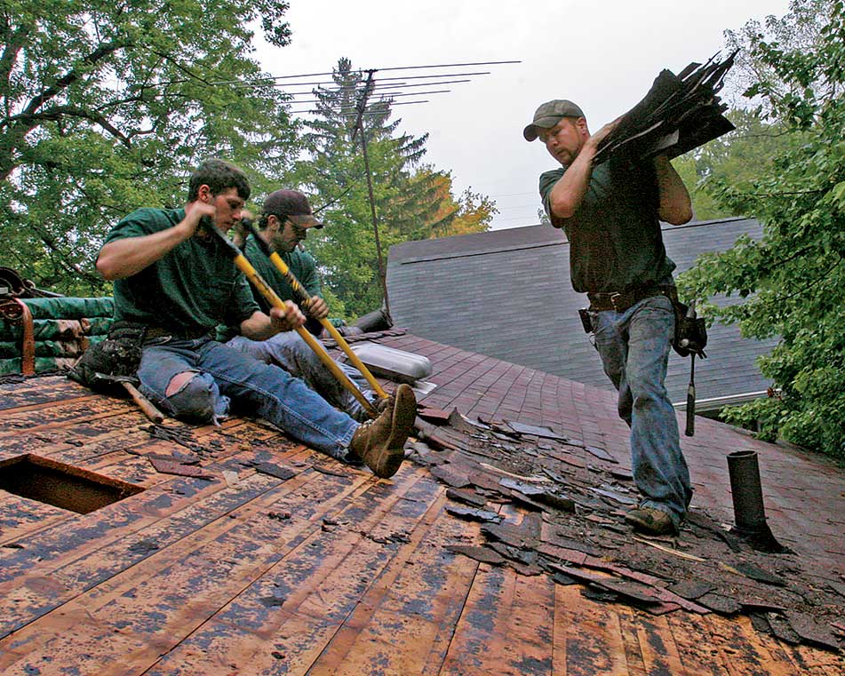 Carry waste to the truck. If the driveway can accommodate a dump truck, carry shingles to it rather than pushing them off the roof onto a tarp. A crew member can switch between tearoff and cleanup.