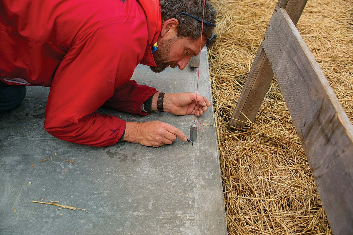 Marking and drilling holes for the post-base anchor bolts.