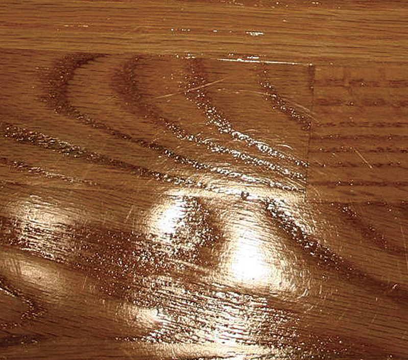 Sloppy sanding shows. Using a worn sanding screen to sand between coats of finish can leave spiderweb-like defects in floor finish.