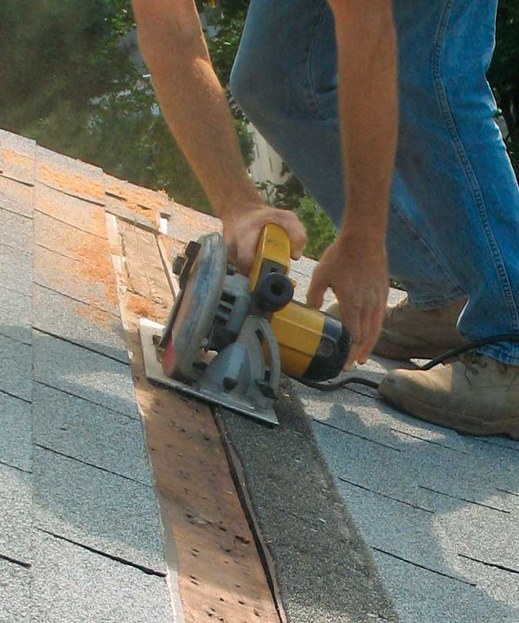 Cut a 1-in.-wide strip of sheathing. Remove two courses of shingles and the nails along the cutline. Use an old carbide sawblade and set the depth of cut to the thickness of the sheathing. Alternatively, you can drill a series of 11⁄2-in.-dia. holes in each rafter bay. 
