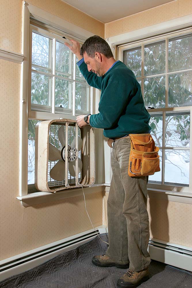 Mount a fan in the window to pull dust out of the house.