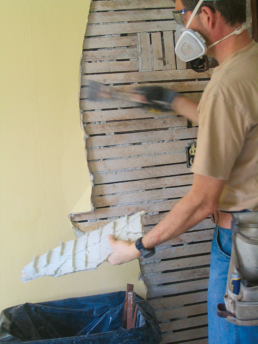 Using a sledgehammer or a framing hammer, tap the plaster between studs.