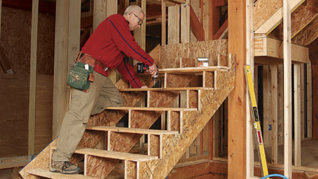 man building a staircase with a landing