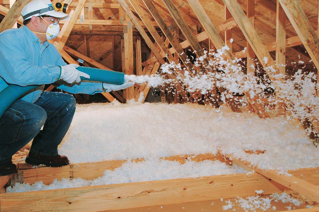 Blown-in fiberglass being applied.