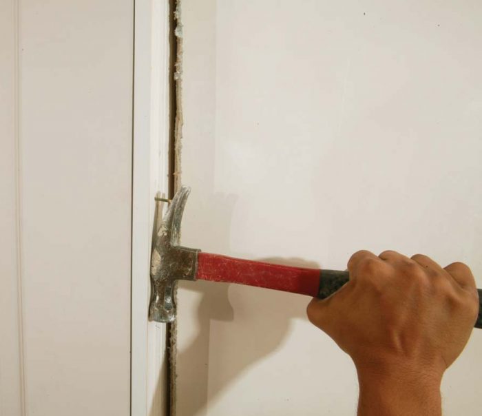 Remove the nail holding the door to the jamb and any cardboard shims stapled to the edge of the door.