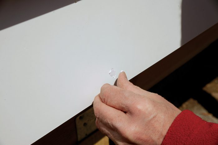putty being used to seal a hole