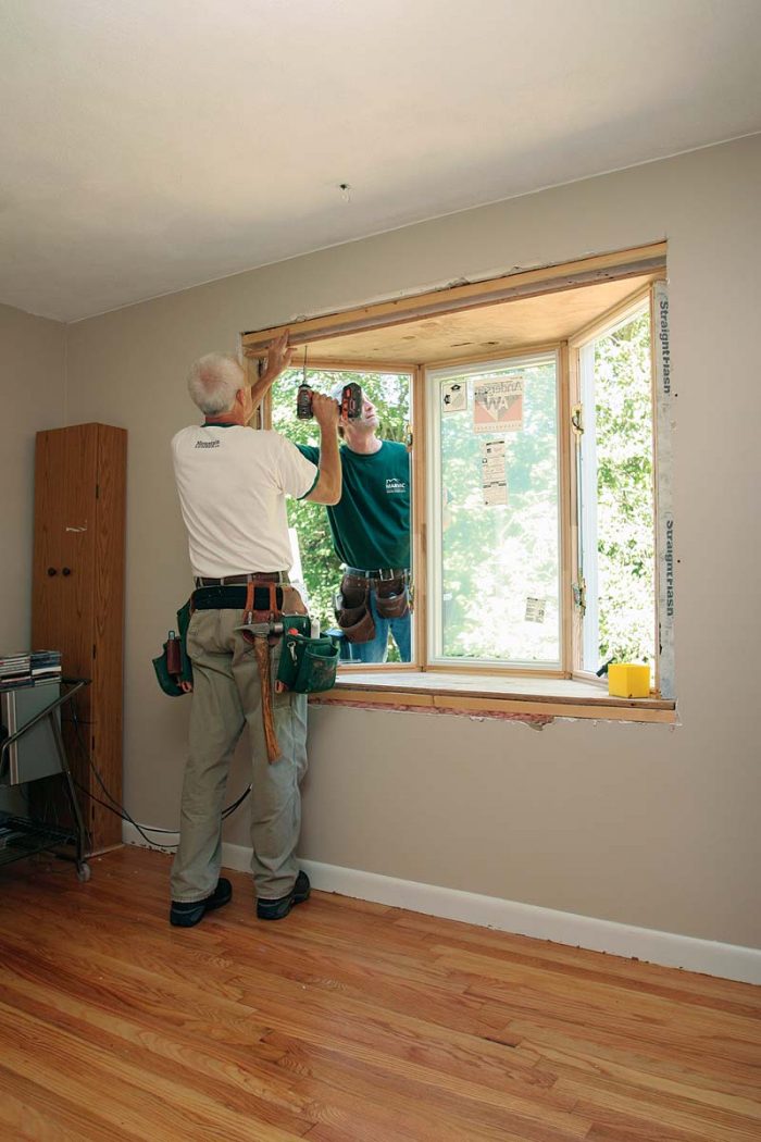 two men Shimming And Fastening the window