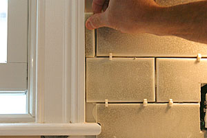 The key is to do your best to avoid narrow slivers of tile butting up against cabinetry or trim on the tile backsplash