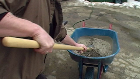 mixing concrete in a wheelbarrow
