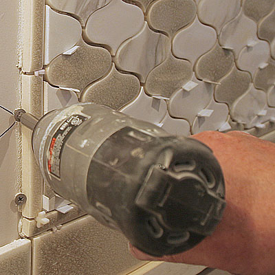 screws in drywall act as support for mosaic tiles