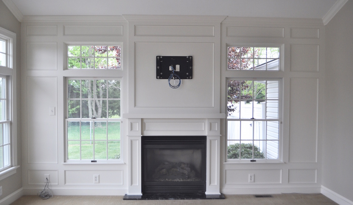 completed paneled fireplace wall with white paint