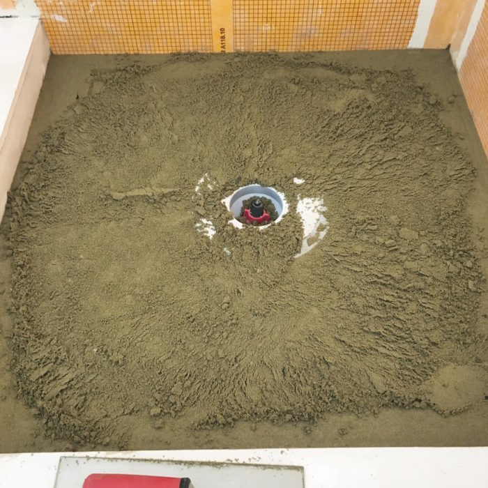 start screeding the inside area of the shower pan using your perimeter screeds and the drain as a gauge to how much mortar needs to be removed