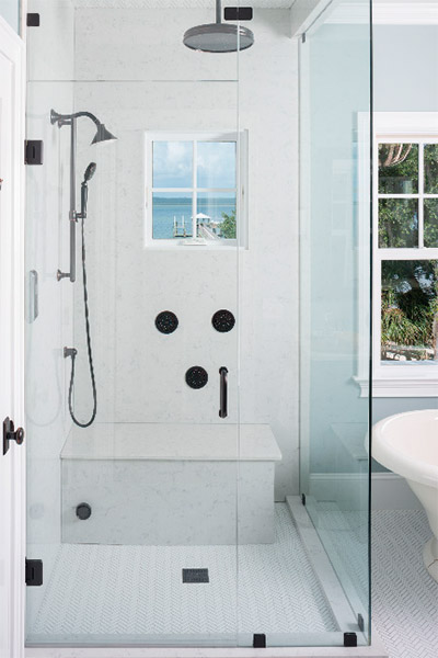 Clean modern touches and a simple interior reflect the alluring Atlantic view just beyond the bathroom windows. The light blue and white color palette complement the room’s tranquil ocean setting and create a serene spa for every morning shower.