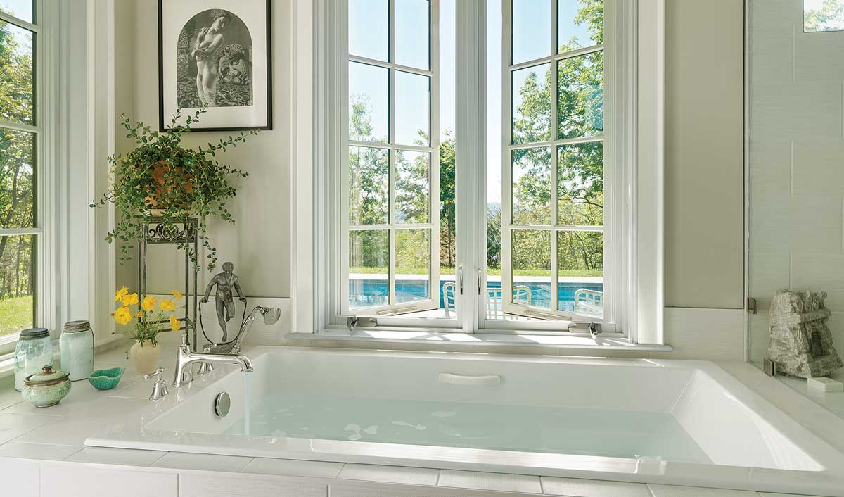 white bathtub facing the window