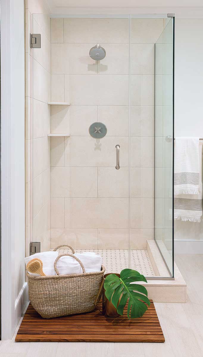 shower with tan tile and glass door