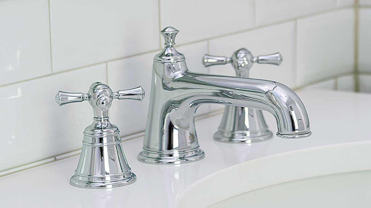 silver faucet with white counter top and white subway tile wall