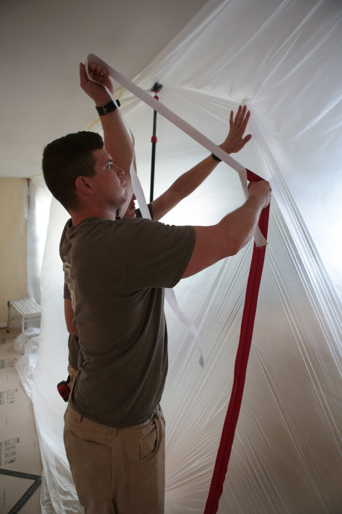 a man installing a temporary dust wall