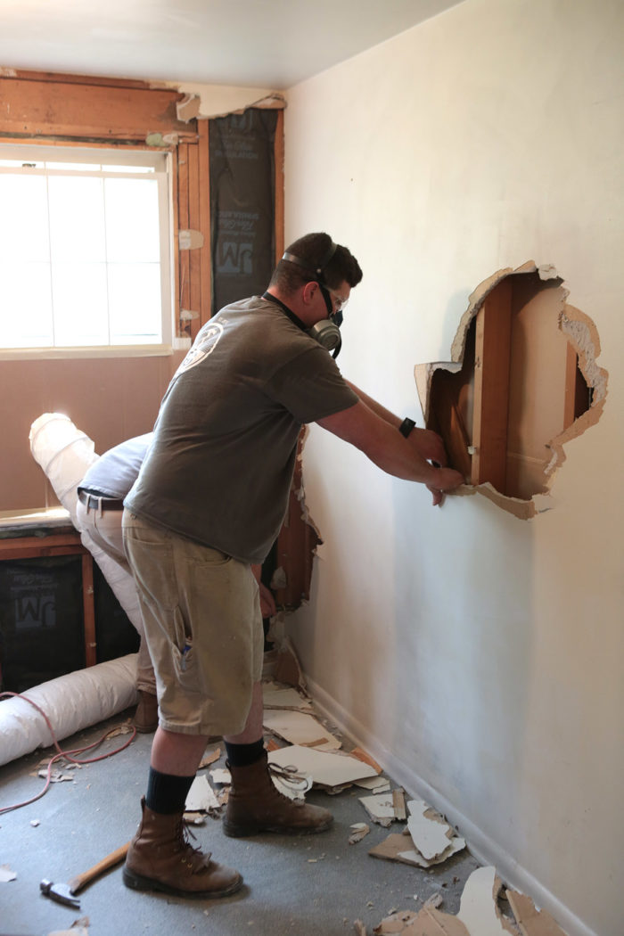 using a framing hammer to remove drywall