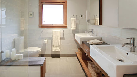Tile and barn style. The horizontal wall tile accentuates the bath’s broad, rectangular shape. A sliding barn-style door adds style without cluttering up the sparse bath design.