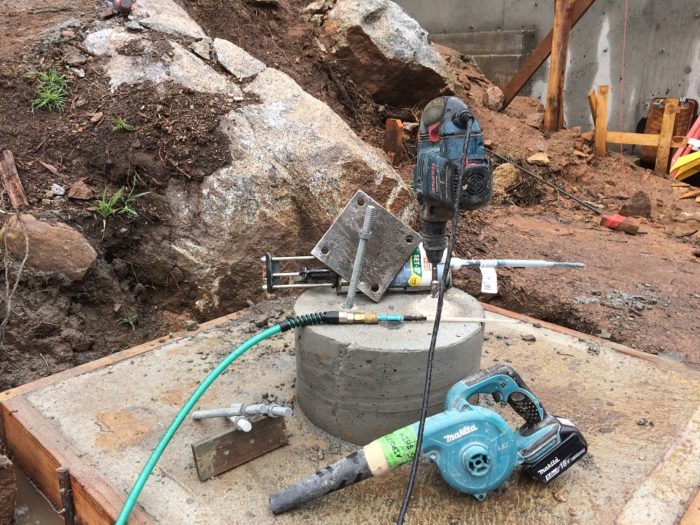 Drilling holes for the anchor bolts. A steel column supporting one of the W10x22 steel beams will land on this footing.