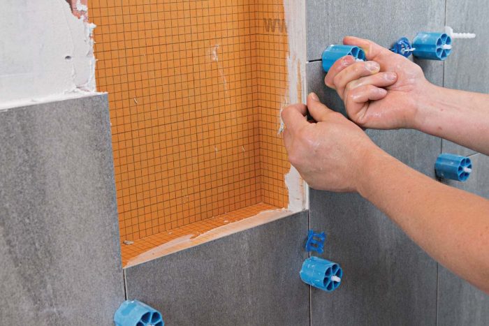To ensure even grout lines, perfectly flush tiles, and tight joints, cut and miter carefully, apply the right amount of thinset, and use a tile-leveling system.