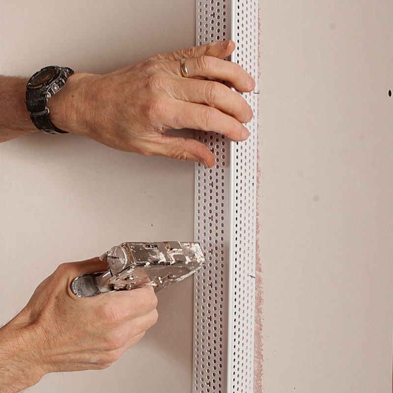 Back it up. Drive divergent staples into the flanges every 6 in. to 8 in. to bolster the bead’s connection to the wall.