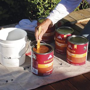 Stir and mix the stain. Stir the cans of stain individually and then mix the cans together in a bucket to ensure even coloring throughout the deck surface.