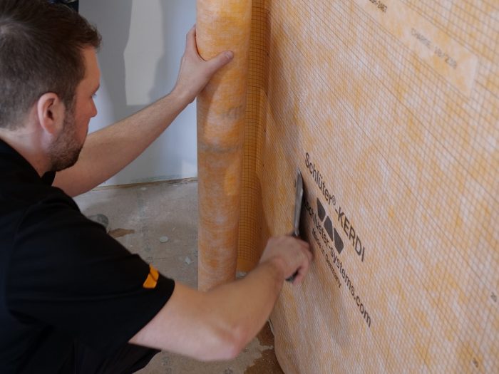 As the Kerdi is embedded in the thinset, a drywall knife ensures adhesion and squeezes out excess thinset.