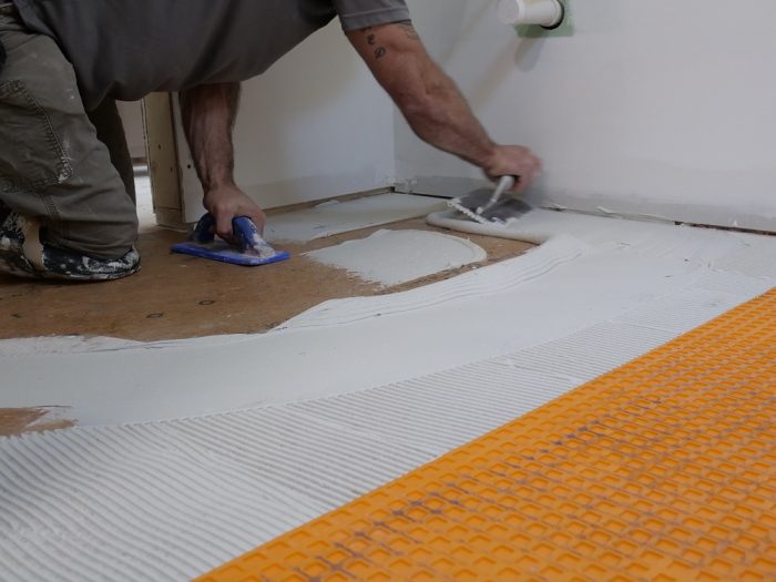 The Schluter-Ditra is installed over the AdvanTech subfloor outside the shower area.