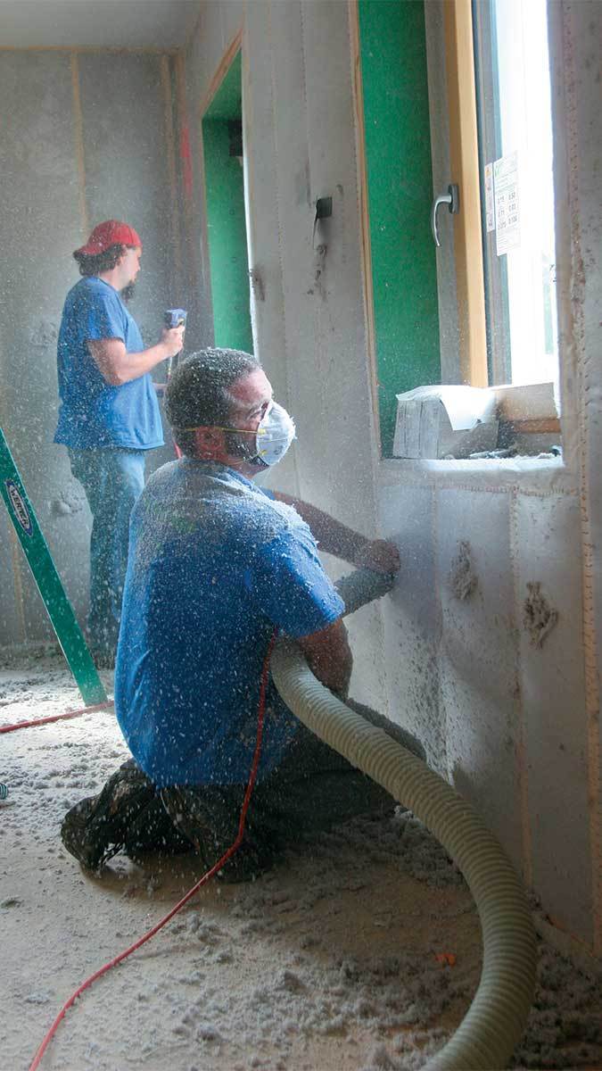 Two workers installing insulation 