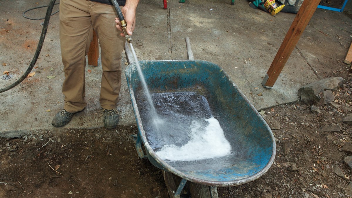 spraying water into wheelbarrow