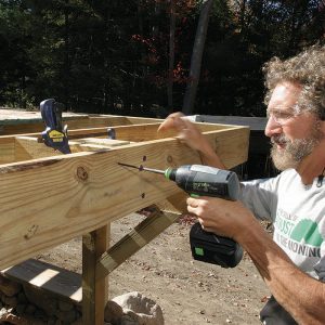 Tie the joists together with blocks. Spaced with a scrap of post material, screw two blocks of joist material between the outer pair of joists using 6-in. FlatLoks.