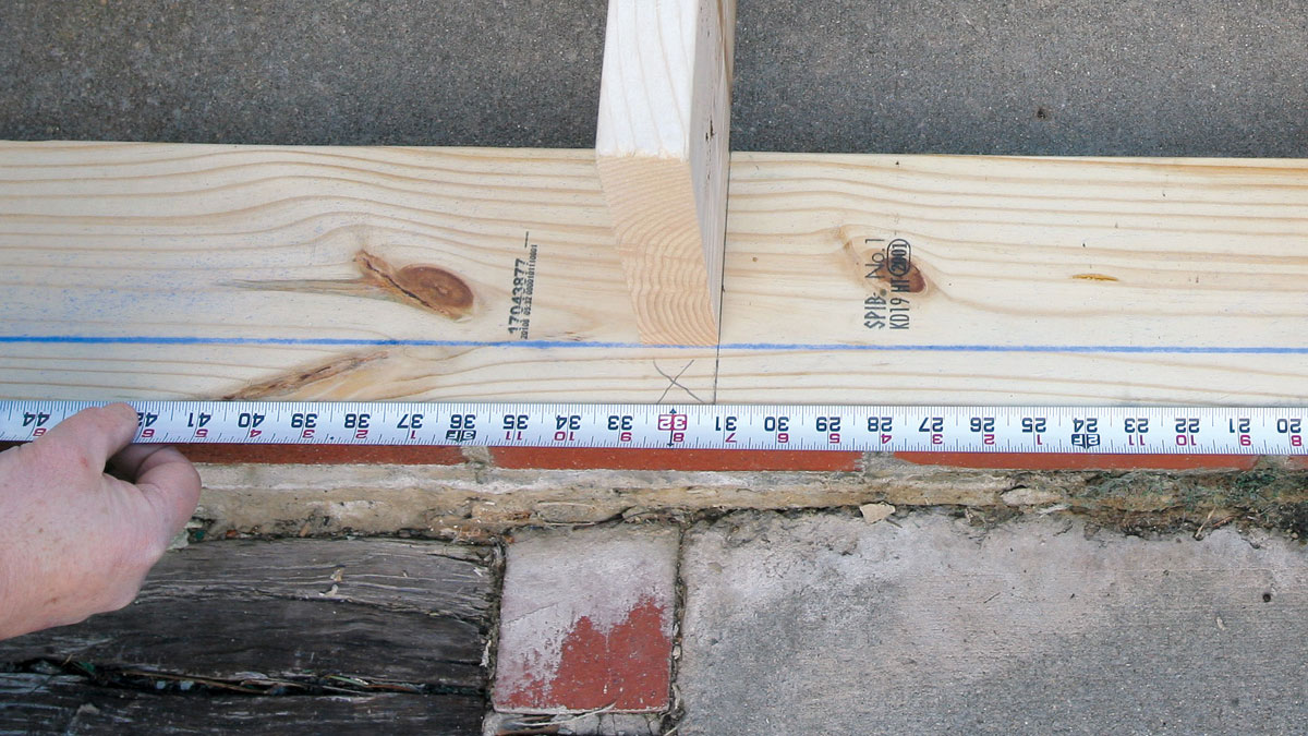 To center the joists on the 16-in. layout, guidelines have to be made ¾ in. (or half the width of 2× stock) to one side of the layout points on the tape.