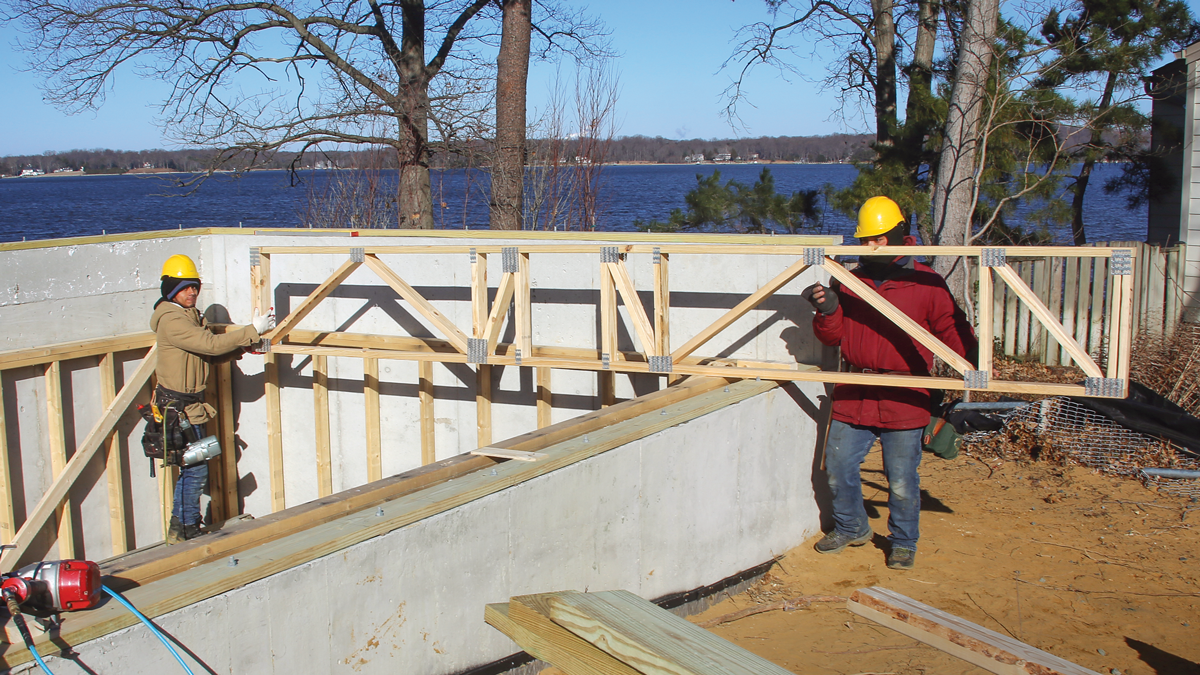 Work away from obstacles. This floor is framed within the foundation on two sides so the grade can be higher against the home in this area. We start at the first truss parallel to the foundation wall because there’s more room here at the beginning of the floor framing than if we worked from the other end of the space.