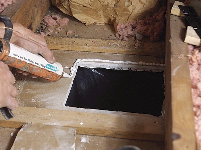 1  Apply a bead of caulk under the flanges before you set the fan box in place.