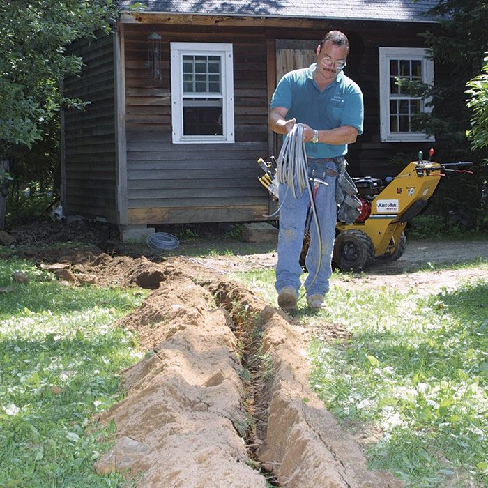 1  As you walk along the trench, unwind the cable. Ideally, it should lie flat in the bottom of the trench.