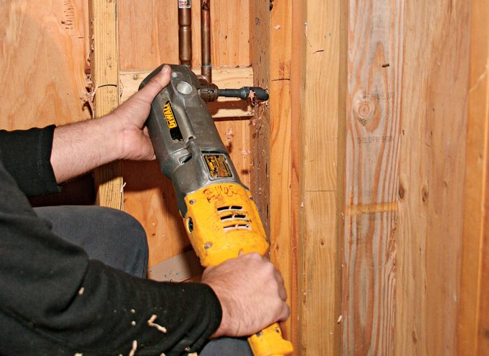 To feed cable through a corner, drill a level hole on one side of the built-up studs.