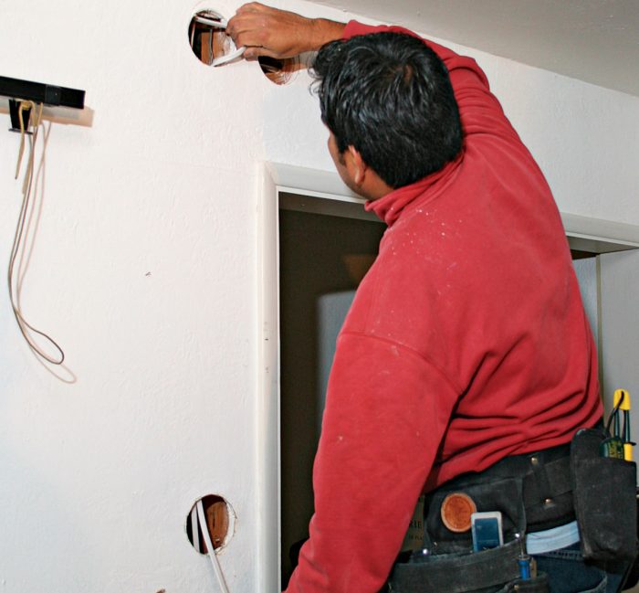Running cable from a ceiling fixture to a wall switch means cutting access holes.