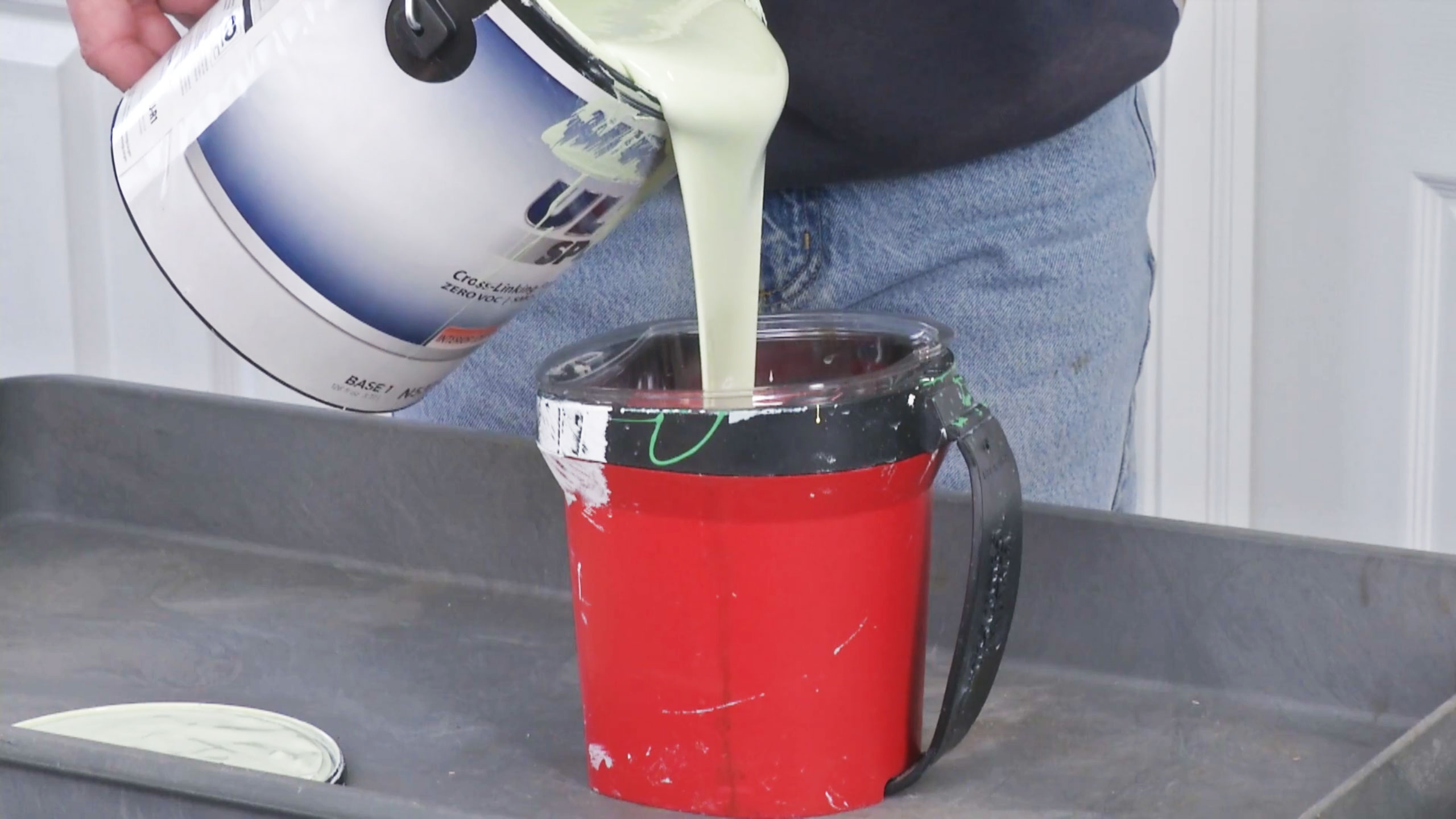 Paint is poured into red paint pail