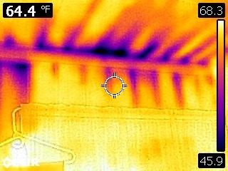 Air leaking at interior wall-to-ceiling connection during a blower door test.
