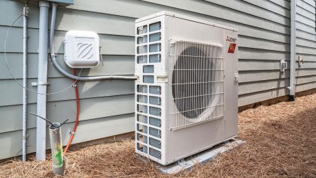 Outdoor HVAC unit against a the side of a house