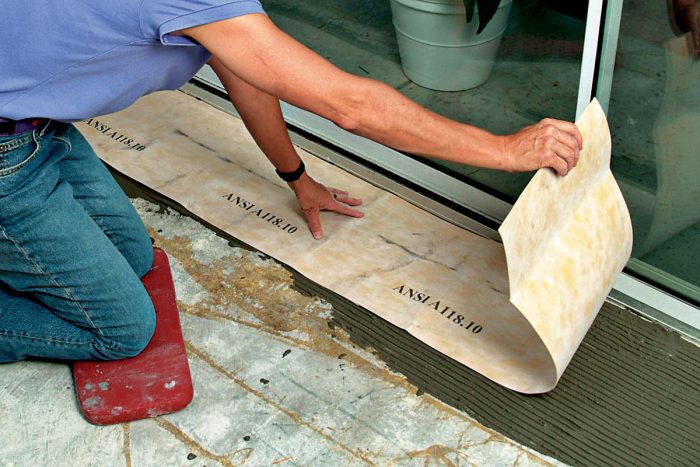 A sheet membrane is adhered to the substrate with thinset.